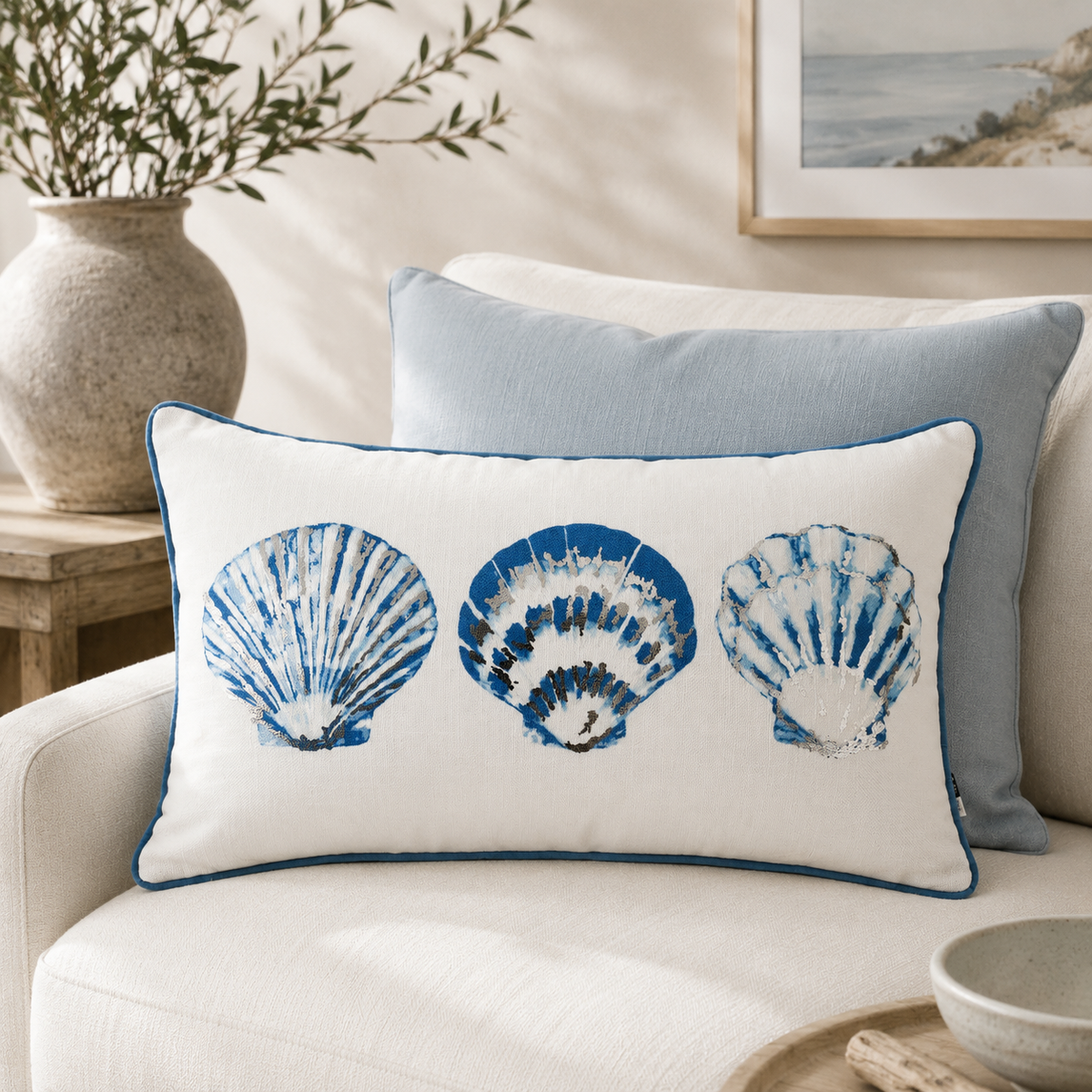 Malini Shella blue shell 30x50 rectangle cushion styled on a light neutral sofa