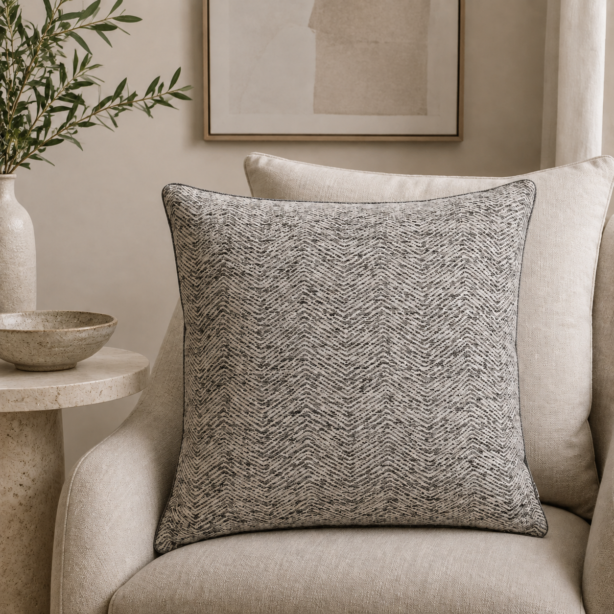 Malini Ripple charcoal woven 43x43 cushion styled on a light neutral armchair