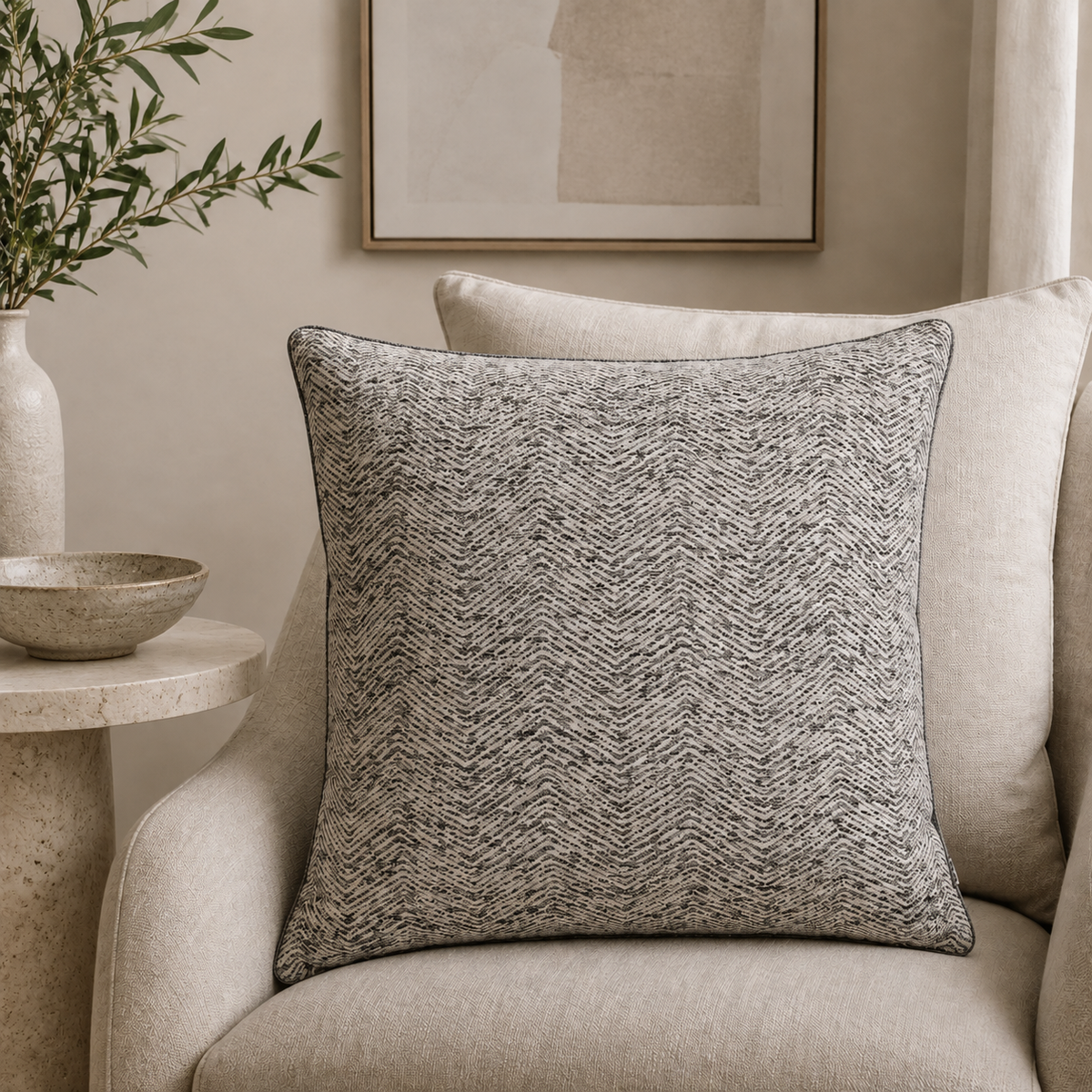 Malini Ripple charcoal woven 43x43 cushion styled on a light neutral armchair