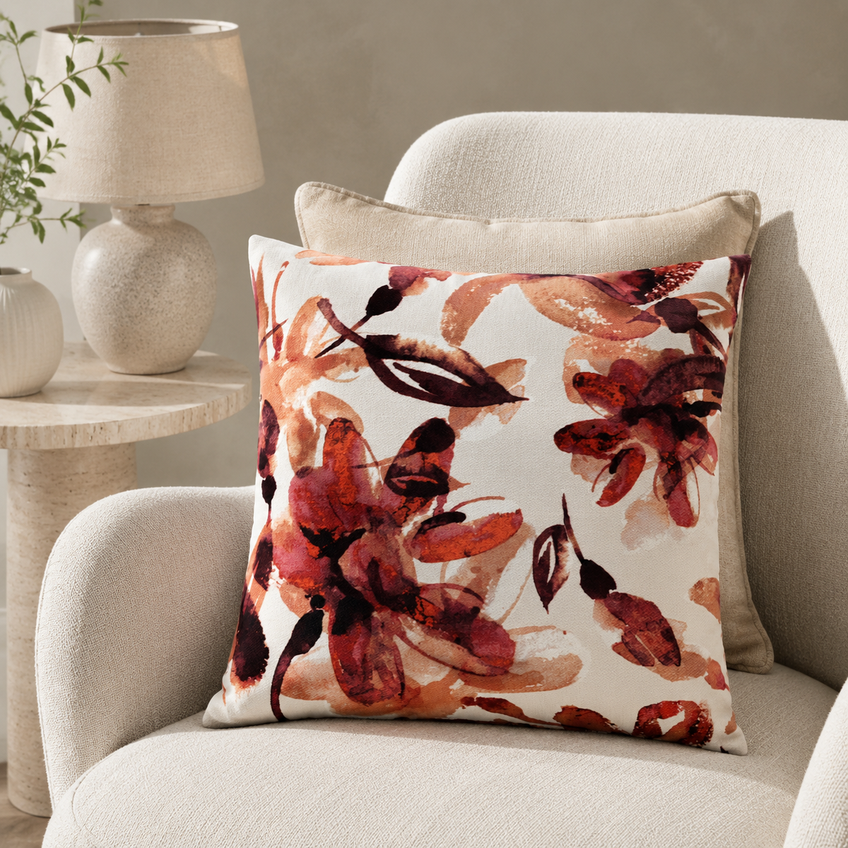 Malini Kelly Rust Orange Floral Square Cushion styled on a neutral armchair