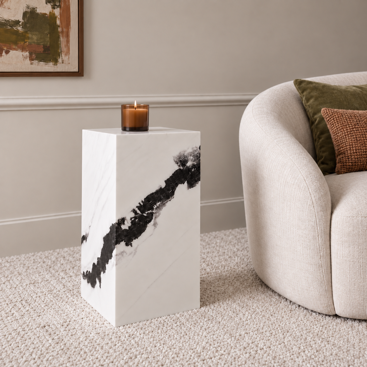 Sur Panda White Marble pedestal with an amber candle beside an ivory chair with olive and terracotta cushions